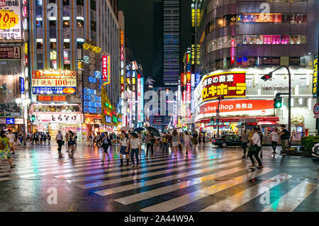 Tokyo, Japan - 29. August 2016: Leute an der Fußgängerampel in Kabukicho Ichibangai mit weltberühmten Marke fashion Stores im Hintergrund. Text i Stockfoto