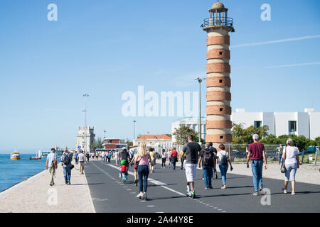 Oktober 6th, 2019, Lissabon, Portugal - Menschen in sonniger Tag neben den Fluss Tejo, Wandern, ausgeführt wird und über Elektroroller. Stockfoto