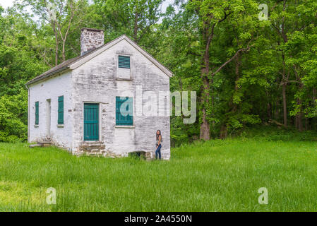 Frau von lock keepers weißes Haus mit grünen Fensterläden und Türen auf der Chesapeake und Ohio Canal Stockfoto