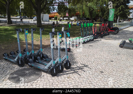 Lissabon, Portugal - 11. AUGUST 2019: Eine Auswahl der Elektroroller außerhalb in Lissabon zur Verfügung mit einem Smartphone App zu mieten. Menschen gesehen werden kann Ich Stockfoto