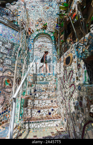 Magic Gardens Philadelphia, Blick auf eine junge Frau die Erkundung der Mosaiken in Philadelphia's Magic Gärten, Philadelphia, Pennsylvania, PA, USA. Stockfoto