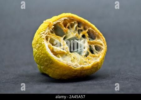 Faule halbe Zitrone auf schwarzem Hintergrund Stockfoto