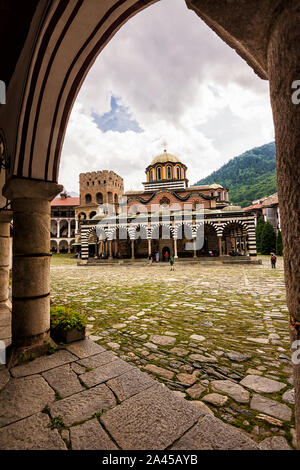 Rila, Bulgarien - 23. Juni 2019: Rila Kloster, einer der wichtigsten touristischen Destinationen und UNESCO-Welterbe in Bulgarien, unter einem Bogen gesehen Stockfoto