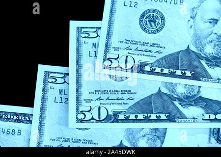 Fünfzig Dollar Banknoten auf schwarzem Hintergrund schließen isoliert. Farbe blau Toning Stockfoto