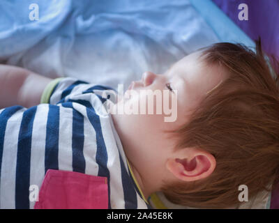 Baby schläft im Bett der Eltern. ausgestreckten Armen erholsamen Schlaf des Babys. close-up. Kind 0-1 Jahre alt. bezaubernd schönen Baby schläft ruhig im Bett, hat eine Stockfoto