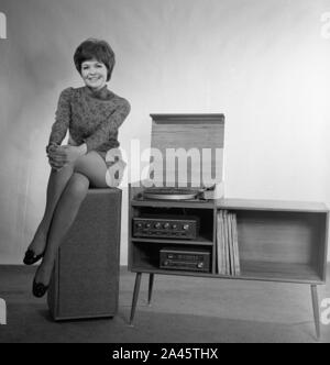 Modell mit kurzen Haaren stellt in einem mini-kleid mit Stereo Sound System c 1969 Foto von Tony Henshaw Archiv Stockfoto