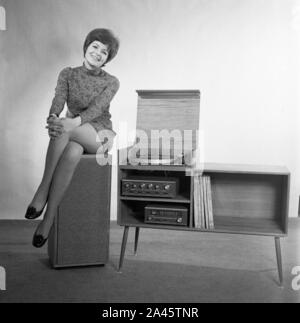 Modell mit kurzen Haaren stellt in einem mini-kleid mit Stereo Sound System c 1969 Foto von Tony Henshaw Archiv Stockfoto