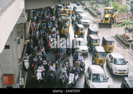 Hyderabad, Indien, 05. Oktober 2019. Zweiräder Reiter und Autofahrer Schutz von Regen unter U-Bahn-Station Viadukt in Hyderabad, Indien. Stockfoto