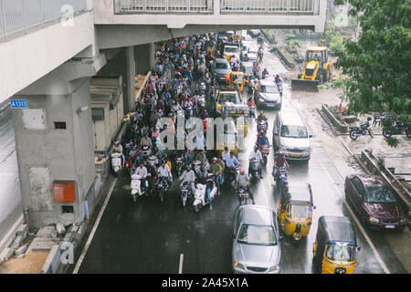 Hyderabad, Indien, 05. Oktober 2019. Zweiräder Reiter und Autofahrer Schutz von Regen unter U-Bahn-Station Viadukt in Hyderabad, Indien. Stockfoto