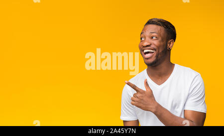 Aufgeregt Afro Mann Zeigefinger beiseite, Studio Shot, Panorama Stockfoto