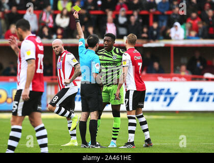 Der Wald Grün Ebou Adams erhält die Gelbe Karte von Schiedsrichter Paul Marsden während der Sky Bet Liga Match im St James Park, Exeter. Stockfoto