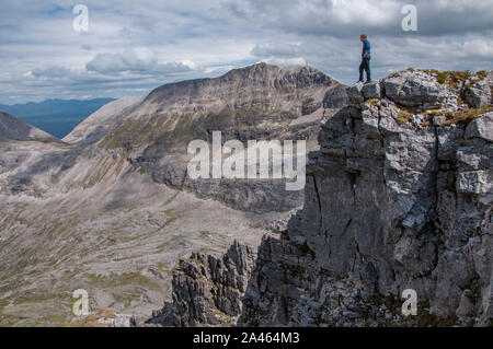 Hill Walker stehen auf dem Gipfel des Spidean Coire nan Clachwith der Beinn Eighe massiv in den Hintergrund, die Torridon, Wester Ross, NW Highlands Stockfoto