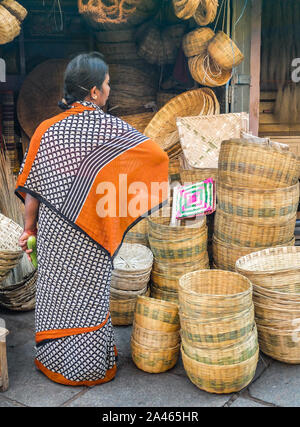 MYSURU (MYSORE), Karnataka/Indien - vom 15. Februar 2018: Eine Frau trägt einen Sari prüft traditionell gewebte Körbe Devaraja market, central Mysore. Stockfoto