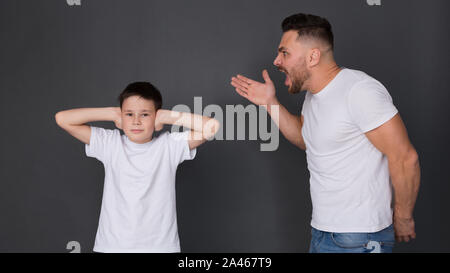 Nervöse Vater Sohn schreien, junge Ohren schließen Stockfoto