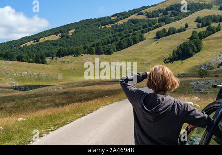 Frau mit Auto (Modell unkenntlich) in der Nähe von sekundären Landschaft Straße durch Mountain Nationalpark Durmitor, Montenegro, Europa, Balkan dinarischen Alp Stockfoto