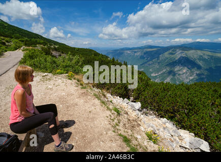 Frau auf Holzbank über malerische Sommer Tara Canyon in Mountain Nationalpark Durmitor, Montenegro, Europa, Balkan Dinarischen Alpen, UNESCO-H Stockfoto