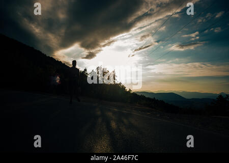 Runner Sprinter bei schneller Geschwindigkeit Ausbildung auf Ziele und Erfolge. Silhouette muskulös männlichen Athleten in Training draußen auf der Straße Stockfoto