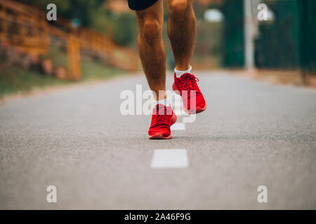 In der Nähe der Füße eines Athleten mit Sport Schuhe auf einem schwierigen Weg Stockfoto
