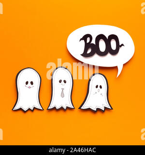 Drei Cute Halloween Geister versuchen, auf Orange, furchtsam zu sein Stockfoto