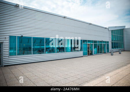 Von außen ein modernes Stahl- und grünes Glas Bürogebäude mit leeren Gehweg. Panoramablick und Perspektive betrachten. Abstrakte, inspirational, künstlerischen und Stockfoto