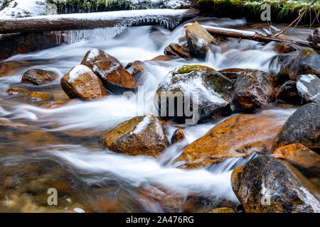 Wasserkaskaden über und über die Felsen in der Kälte mit Eis auf ein Protokoll Stockfoto