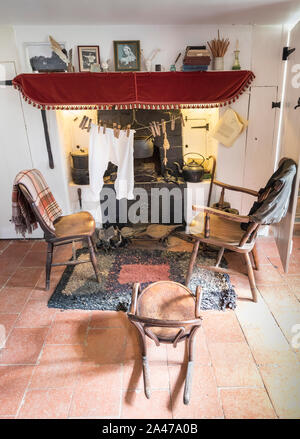 Stühle um Kamin im Museum Ausstellung, Kröte Loch Cottage, Norfolk Broads, Norfolk, England, Großbritannien Stockfoto
