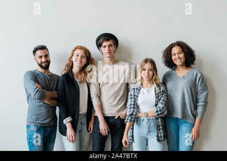 Fröhliche interkulturelle Freunden im stilvollen Casualwear zu Ihnen schauen Stockfoto