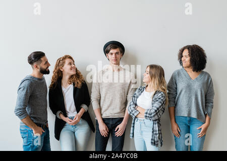 Vier Glückliche Jugendliche in casualwear mit ihren stattlichen Freund suchen Stockfoto
