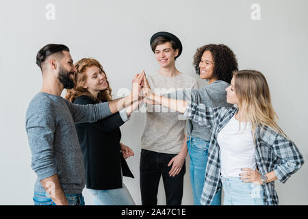 Gruppe von jungen interkulturelle Freunde in casualwear Hohe - fünf Stockfoto