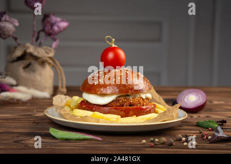 Cheeseburger aus gehacktem Rindfleisch Schnitzel mit Tomaten. Hellen Hintergrund. Close-up. Stockfoto
