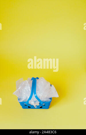 Polyäthylenbeutel im Warenkorb auf gelben Hintergrund. Stockfoto