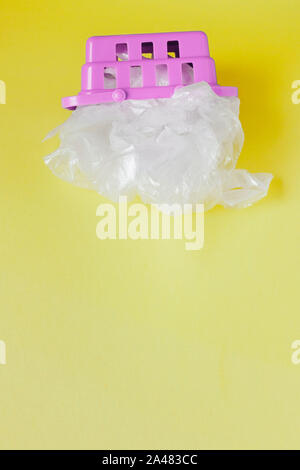 Polyäthylenbeutel im Warenkorb auf gelben Hintergrund. Stockfoto