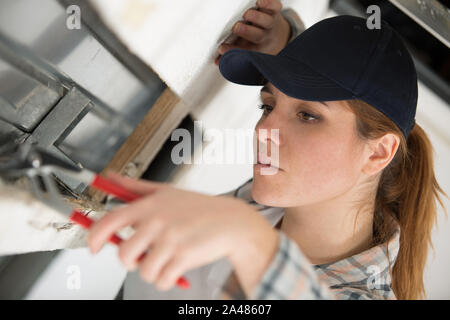 Frau arbeitet an einem Fensterrahmen Stockfoto