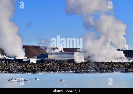 Svartsengi, Island. Gerade über dem Wasser der Blue Lagoon Dampf und Rauch unten aus dem Svartsengi Geothermie-kraftwerke. Stockfoto