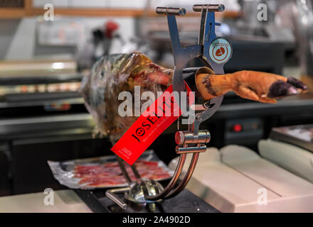 Madrid, Spanien - 4. Juni 2017: Das ganze Bein der serrano Iberico Schinken auf einem Ständer auf Anzeige an einem Metzger in einem Markt, in Madrid, Spanien Stockfoto