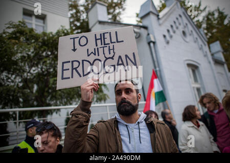 Warschau, Polen. 11 Okt, 2019. Ein Mann gesehen, die ein Schild mit der Aufschrift "Zur Hölle mit Erdogan' Während des Protestes. Hunderte Leute an die türkische Botschaft in Warschau versammelt, um gegen die türkische Invasion des nördlichen Syrien zu protestieren und ihre Solidarität mit dem kurdischen Volk zu zeigen. Die Demonstranten waren die ursprünglichen Kurden, die mit der Flagge von Kurdistan, YPG (durch den Menschen Schutz Einheiten), PKK (Arbeiterpartei Kurdistans) und mit dem Bild von Abdullah Öcalan - PKK-Führer. Credit: SOPA Images Limited/Alamy leben Nachrichten Stockfoto