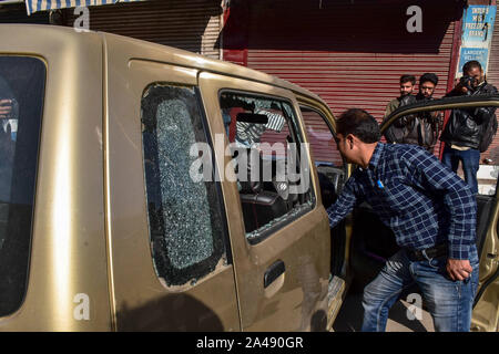 Srinagar, Indien. 12 Okt, 2019. Eine lokale prüft sein Auto in eine Granate Angriff in Srinagar beschädigt. Zahlreiche Menschen wurden in eine Granate Angriff durch mutmaßliche Militante hier in Srinagar, am Samstag Nachmittag verletzt. Die Explosion beschädigt auch Windows von Fahrzeugen, die in der Nähe geparkt. Der Angriff kommt trotz fester Sicherheit seit der Mitte der Artikel 370, der besondere Status in Jammu und Kaschmir Zuschüsse am 5. August abgeschabt. Credit: SOPA Images Limited/Alamy leben Nachrichten Stockfoto