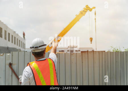 Engineering Tragen eines weißen Schutzhelm vor der Baustelle. Konzepte für die Steuerung und Kontrolle der Bau Genauigkeit Stockfoto