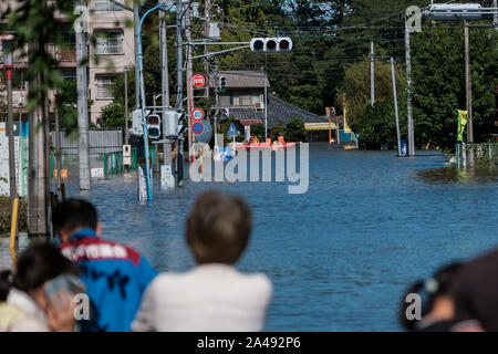 Kawagoe, Japan. 13 Okt, 2019. Leute schauen auf ein Rettungsteam in einem Boot, in einem Bereich, in Kawagoe city überschwemmt, in Japan am 13. Oktober 2019. Leistungsstarke typhoon Hagibis und Nachwirkungen Flut riss über dem Land und tötete 11 Menschen und Dutzende von vermissten Personen. Kawagoe. Quelle: Lba Co.Ltd./Alamy leben Nachrichten Stockfoto