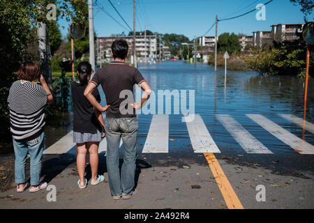 Kawagoe, Japan. 13 Okt, 2019. Eine Familie Blick in eine Nachbarschaft in Kawagoe city überschwemmt, in Japan am 13. Oktober 2019. Leistungsstarke typhoon Hagibis und Nachwirkungen Flut riss über dem Land und tötete 11 Menschen und Dutzende von vermissten Personen. Kawagoe. Quelle: Lba Co.Ltd./Alamy leben Nachrichten Stockfoto