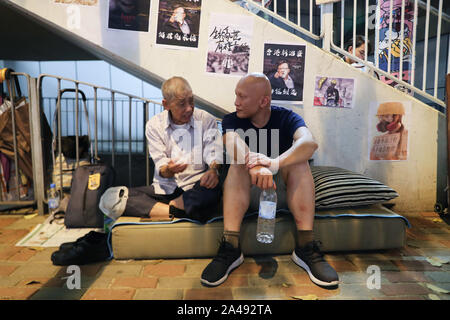 Hongkong, China. 12 Okt, 2019. Zwei Senioren chatten außerhalb Polizei Hauptquartier während der Proteste. Hongkong Proteste für den 5. Monat fort. Mehr Demonstrationen und Kundgebungen statt, einschließlich der silbernen Haar, ein 48 Stunden Streik der Sitzen friedlich außerhalb Polizeipräsidium. Credit: SOPA Images Limited/Alamy leben Nachrichten Stockfoto