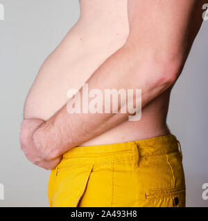 Die Hände des Menschen mit mehr Bauch Fett. Close-up Stockfoto