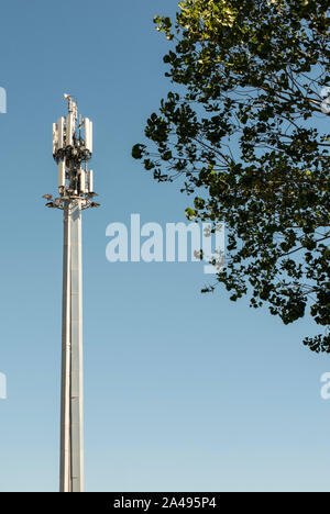 5G Antenne außerhalb der Stadt. GSM-Antenne in der Natur. Neue 5G-Technologie für Internet Konzept. Neuen Fernsehturm und Bäume. Stockfoto