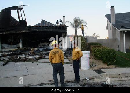 Sylmar, Kalifornien, USA. 12 Okt, 2019. Fire Crew aus Santa Maria, Summerland und Carpinteria, CA eine verbrannte Haus durch Rücksendung evakuiert Nachbarn genannt. Hat das Feuer wieder in der Wohngegend der Porter Ranch Bereich Sylmar und Granada Hills, östlich von Los Angeles gezündet. Ein Brandopfer Tesla können Sie in der Garage gesehen werden. Santa Ana Winde verursacht ein Bürste Feuer in den nördlichen Ausläufern des San Fernando Valley am Okt. 11, Brennen von 7.500 Hektar, mindestens 31 Strukturen, darunter viele Wohnungen, und zwingen Tausende zu fliehen. Credit: Amy Katz/ZUMA Draht/Alamy leben Nachrichten Stockfoto