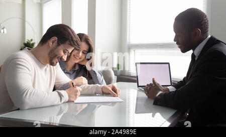 Seitenansicht der glückliche junge Familie Paar unterzeichnen Vertrag. Stockfoto