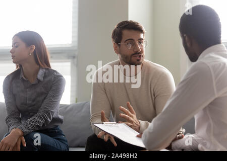 Junge unzufrieden Frau gelangweilt, während Mann im Gespräch mit dem Psychologen. Stockfoto