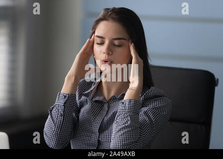 Betonte Frau Tempel zu massieren, zu versuchen, die Kontrolle der Betriebsdruck im Büro. Stockfoto