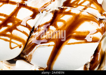 Große Portion Vanilleeis mit Schokoladenglasur bestreichen. Stockfoto