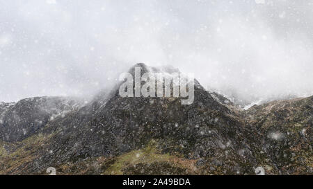 Atemberaubende Moody dramatische Winterlandschaft mountain Bild von schneebedeckten Y Garn in Snowdonia Stockfoto