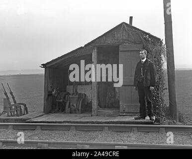 Einen uniformierten Eisenbahner an seinem railside Hütte auf dem Land in London, Tilbury und Southend Railway (LTSR), Essex, England, UK c 1910. Die Ausrüstung besteht hier aus Schalter und Hebel den Arbeiter zu erlauben, der manuell zu Weichen und Signale auf der Linie. Stockfoto